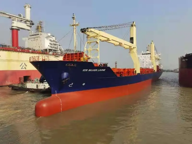 Her bow alongside a berth with containers stowed on deck and her cranes topped.